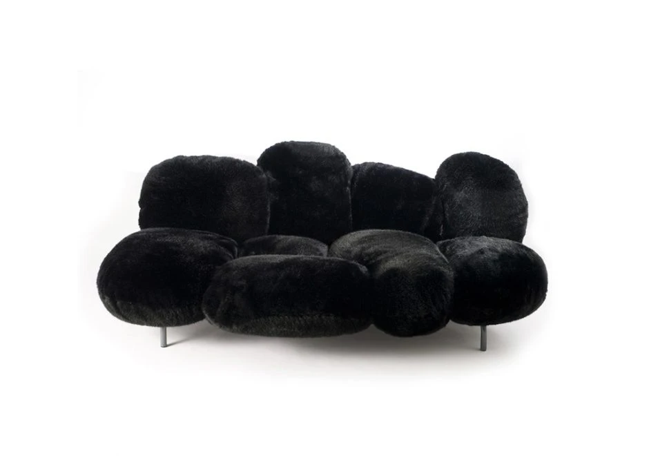 Sofá de design moderno, com estrutura de aço e estofado em pelúcia preto, visto de frente, em um fundo branco.