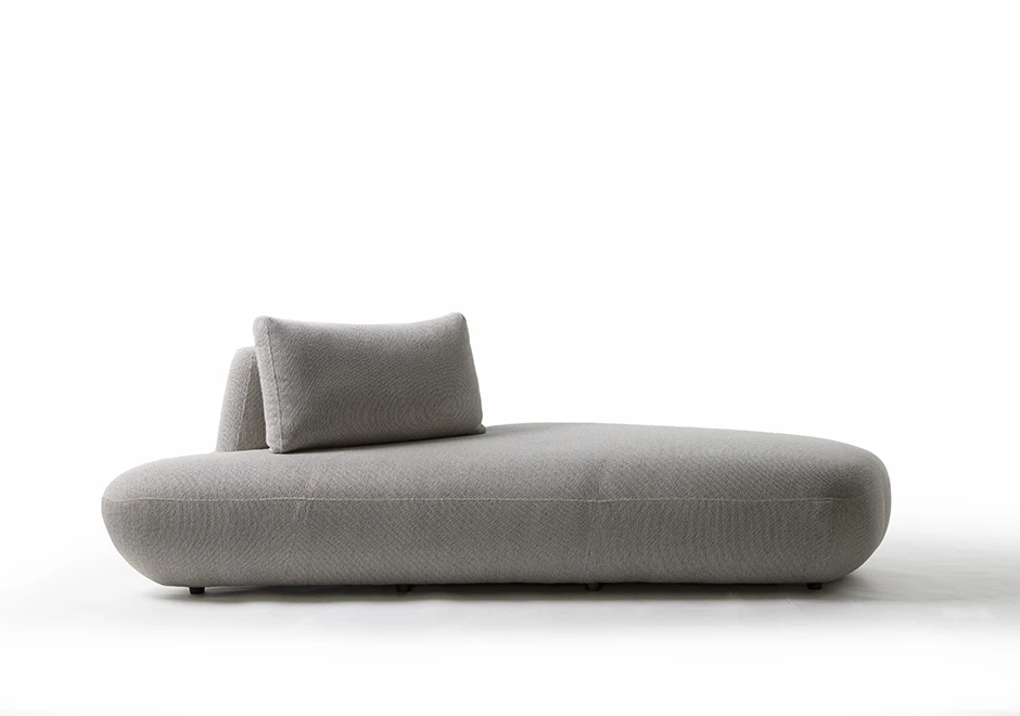 Um módulo de sofá Pedras modular, com estrutura de madeira, com almofadas decorativas, estofado em tecido cinza, visto de frente, em um fundo branco.