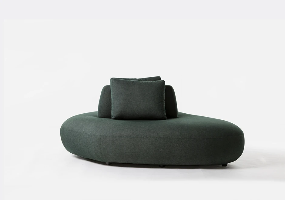 Um módulo de sofá Pedras modular, com estrutura de madeira, com almofadas decorativas, estofado em tecido verde, visto de frente, em um fundo branco.