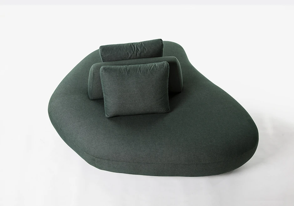 Um módulo de sofá Pedras modular, com estrutura de madeira, com almofadas decorativas, estofado em tecido verde, visto de cima, em um fundo branco.