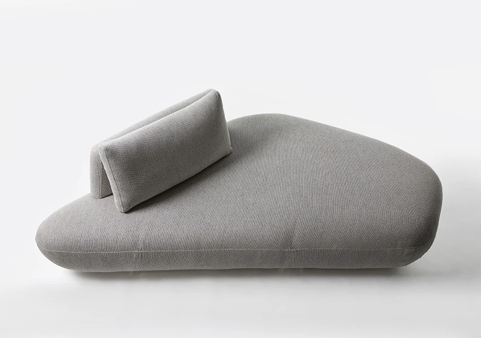 Um módulo de sofá Pedras modular, com estrutura de madeira, com almofadas decorativas, estofado em tecido cinza, visto de cima, em um fundo branco.