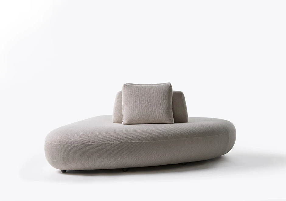 Um módulo de sofá Pedras modular, com estrutura de madeira, com uma almofada decorativa, estofado em tecido cinza, visto de frente, em um fundo branco.