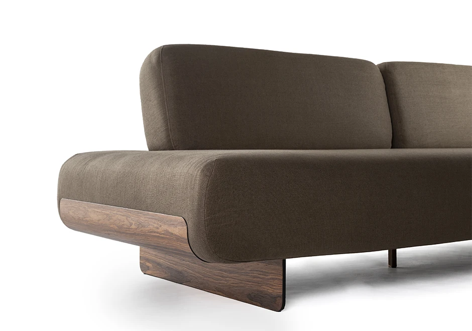 Imagem aproximada de sófa modular, com base de metal, revestido em espuma, estofado em tecido cinza claro, visto de frente em um fundo branco.