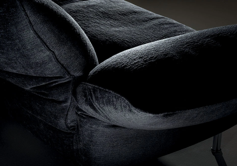 Detalhe de sofá modular estofado em tecido preto, visto de cima.