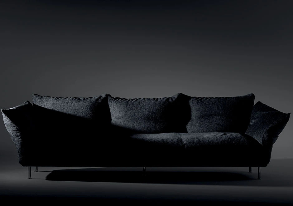 Sofá modular estofado em tecido preto, visto de frente, em um fundo branco.