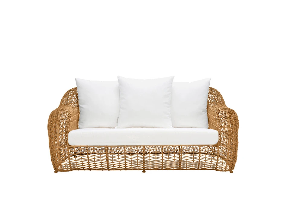 Sofá de três lugares de tecido branco, almofadas brancas e estrutura em fibra sintética trançada. Sofá de frente e em fundo branco.