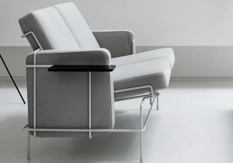 Sofá modular, com estrutura em aço e almofadas em espuma, em tecido branco, visto de lado em um fundo branco.