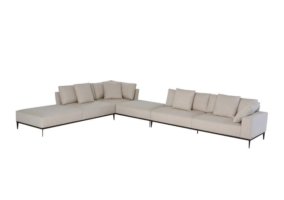 Sofá modular branco, com pés em aço escuro, com diversas almofadas, visto na diagonal, em um fundo branco