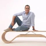 Guto Índio da Costa veste camisa azul clara e calças jeans