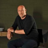 Cristophe Pillet veste preto e posa sentado.