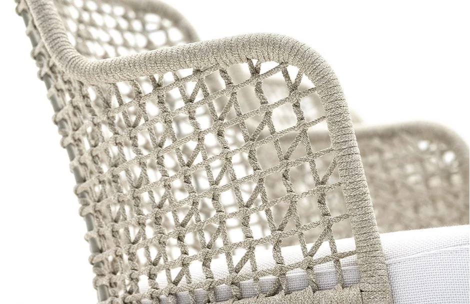 Detalhe de cadeira assinada com estrutura em madeira Iroko natural e assento revestido em tecido bege e encosto com estrutura de alumínio com acabamento em corda trançada à mão ou tecido.