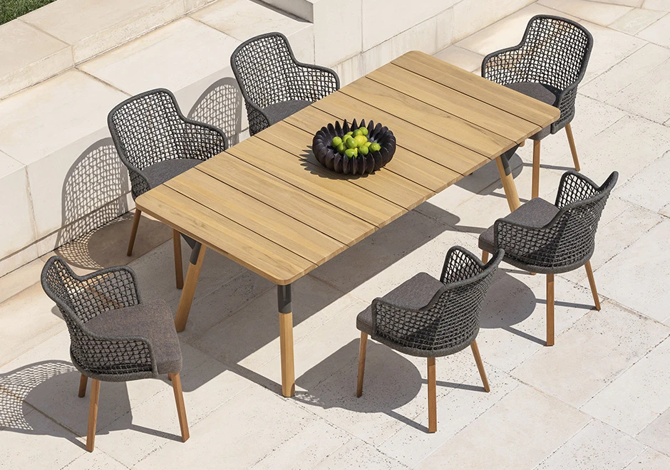 Seis cadeiras assinadas com estrutura em alumínio com pintura eletrostática cinza e assento revestido em tecido e encosto com estrutura de alumínio com acabamento em corda trançada à mão ou tecido. Visto de cima em uma area externa.