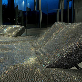 Detalhe de sofá de design futurista, com estrutura de aço e mecanismo flexível com diferentes inclinações, em tecido tramado com cristais Swarovski.