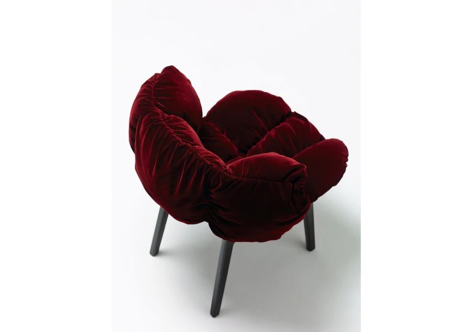 Uma cadeira Irmãos Campana com estrutura de madeira na cor preta, assento e encosto de veludo na cor vermelha, em um fundo branco.