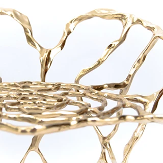 Detalhe de assento de banco de design em bronze polido ou natural, em um fundo branco.