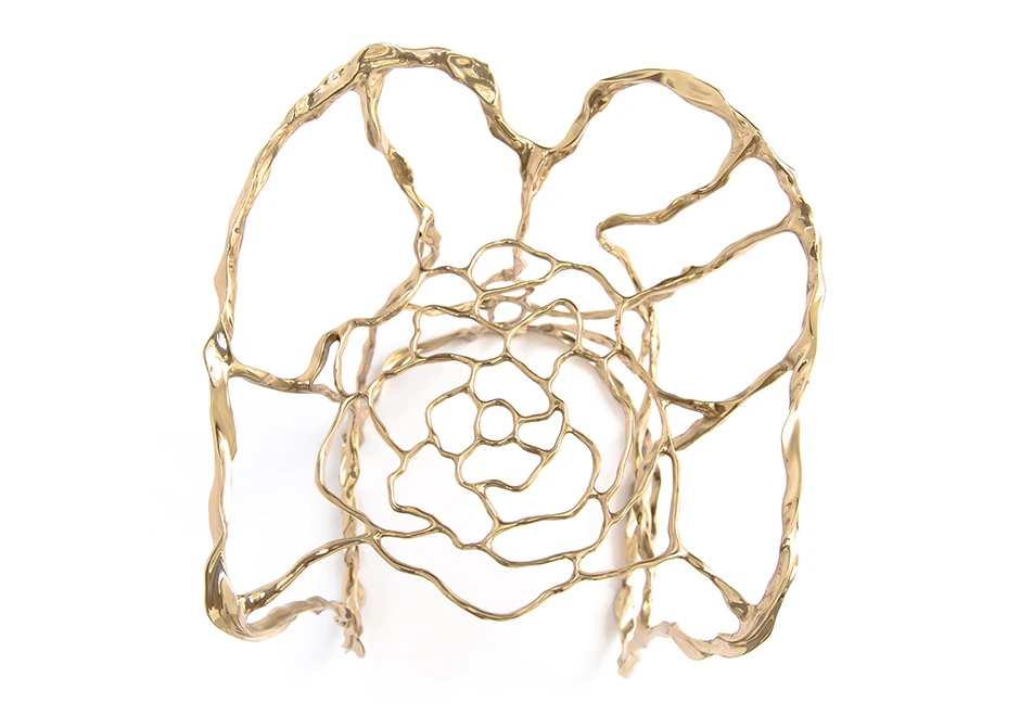 Banco de design em bronze polido ou natural, visto de cima em um fundo branco.