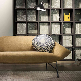 Sofá contemporâneo de 2 lugares com estrutura de metal, estofado em tecido bege, visto de frente, em uma sala moderna.