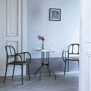 Duas cadeiras empilhaveis assinadas, com estrutura de polipropileno e fibras de vidro, com pintura acetinada, vista de frente em uma sala de jantar.