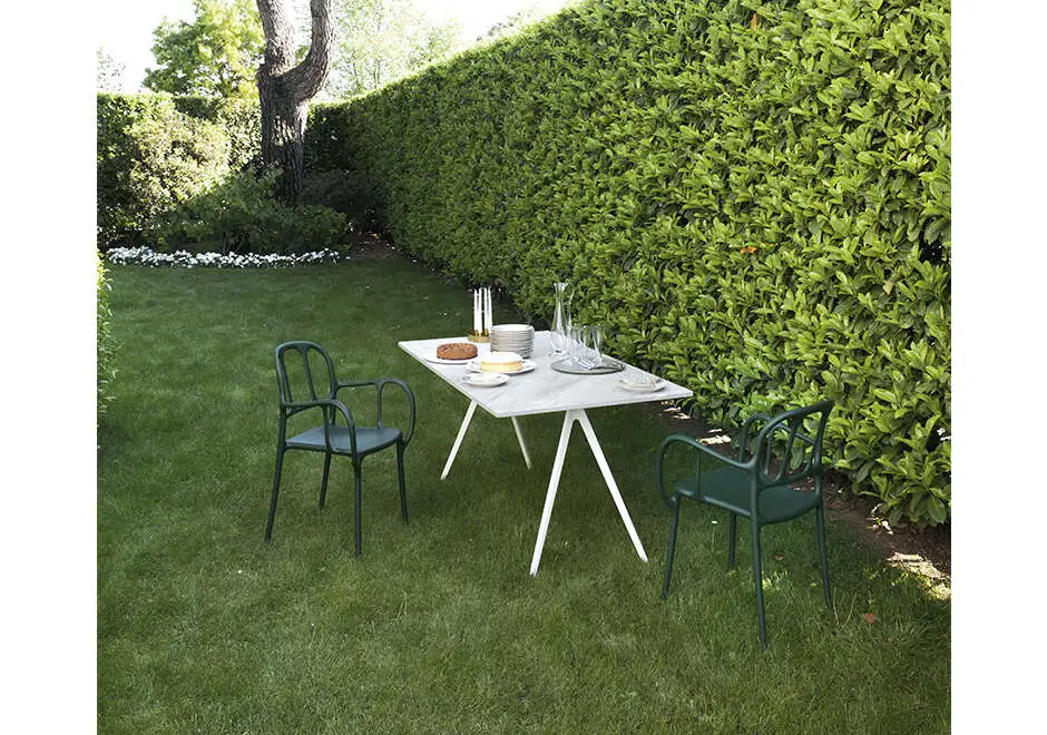 Duas cadeiras empilhaveis assinadas, com estrutura de polipropileno e fibras de vidro, com pintura acetinada na cor verde, vista de cima em uma area externa.