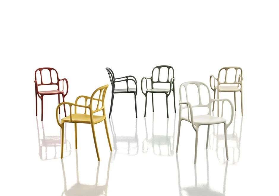 Várias cadeiras empilhaveis assinadas, com estrutura de polipropileno e fibras de vidro, com pintura acetinada em várias cores, vista de frente em um fundo branco.