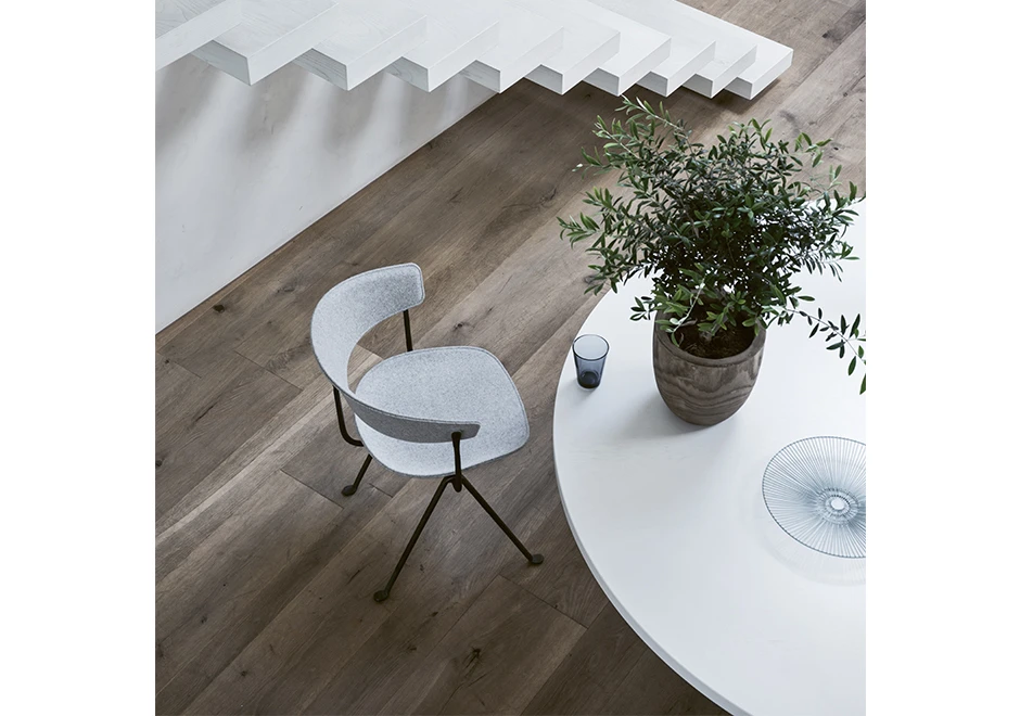 Cadeira de design com estrutura de ferro galvanizado ou pintado; assento e encosto de polipropileno em tecido branco, vista de cima em uma sala.