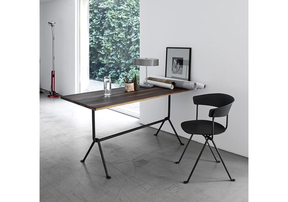 Cadeira de design com estrutura de ferro galvanizado ou pintado; assento e encosto de polipropileno preto, vista de lado em uma sala.