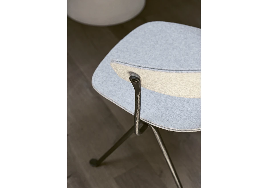 Detalhe de cadeira de design com estrutura de ferro galvanizado ou pintado; assento e encosto de polipropileno em tecido branco, vista de cima em uma sala.