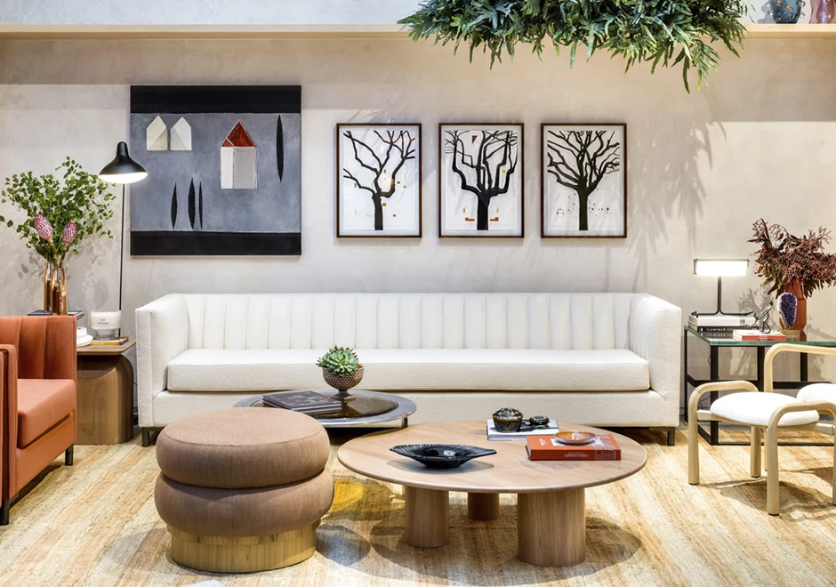 Sofá de design em ondas, com estrutura de madeira, pés em metal, estofado em tecido branco, visto de frente, em uma sala moderna.