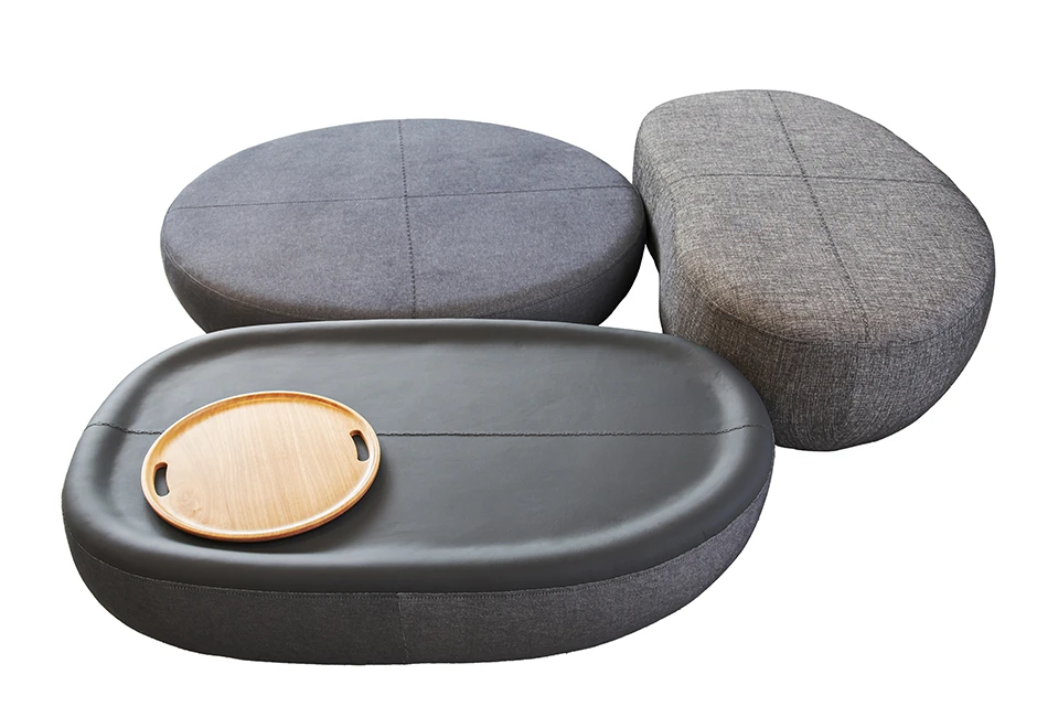 Pufes com estrutura de madeira, 3 opções de formato e acabamentos diferenciados em tecido e/ou couro cinza, vistos de cima em um fundo branco.