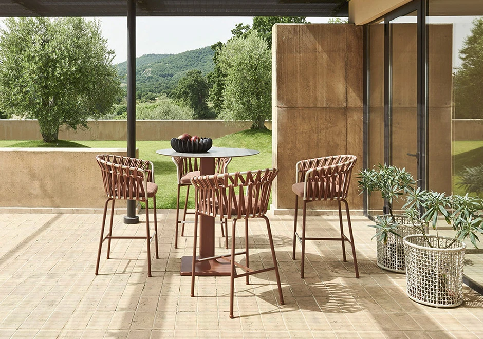 Tres bancos Emma Cross em volta de uma mesa ao ar livre