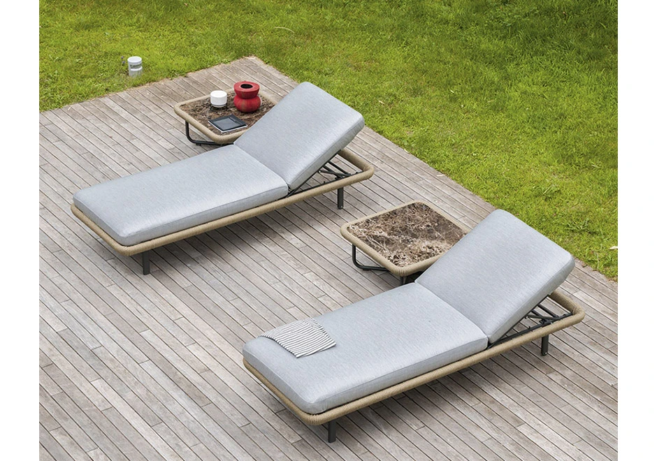 Duas chaise longue com estrutura e rodinhas em alumínio pintado, corda de fibra sintética de cânhamo, almofada em tecido branco, vistas de costas em uma area externa de piscina.