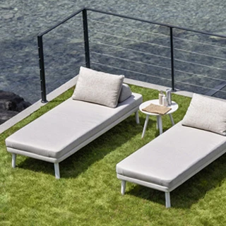 Duas chaise longue com estrutura de alumínio com pintura eletrostática, pés em alumínio pintado ou madeira Iroko natural, tecido na cor bege, visto de cima em uma area externa.