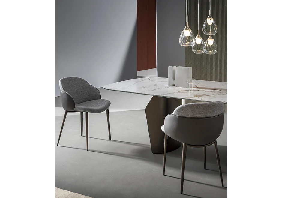 Duas cadeiras de design com estrutura de aço com pintura eletrostática e acabamento em madeira e estofada em tecido cinza, vistas de lado em uma sala.