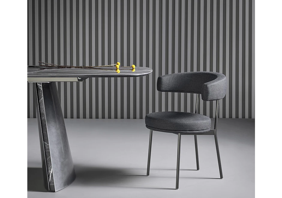 Cadeira de design com estrutura tubular de aço com acabamento em pintura eletrostática preta, vista de frente em uma sala moderna.