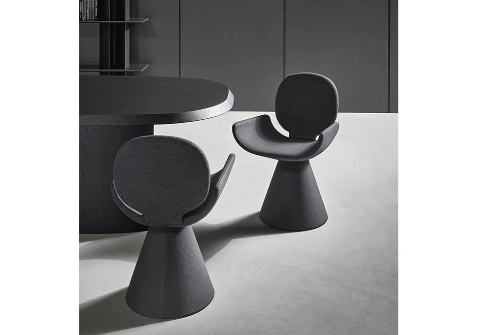 Duas cadeiras de design com estrutura de aço cônica e assento e encosto em espuma de poliuretano, estofada em tecido cinza, vistas uma de frente para a outra em uma sala.