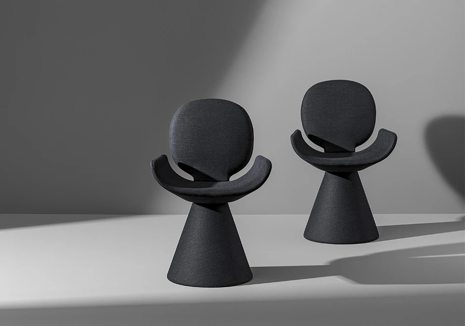 Duas cadeiras de design com estrutura de aço cônica e assento e encosto em espuma de poliuretano, estofada em tecido cinza, ambas vistas de frente em um fundo branco.