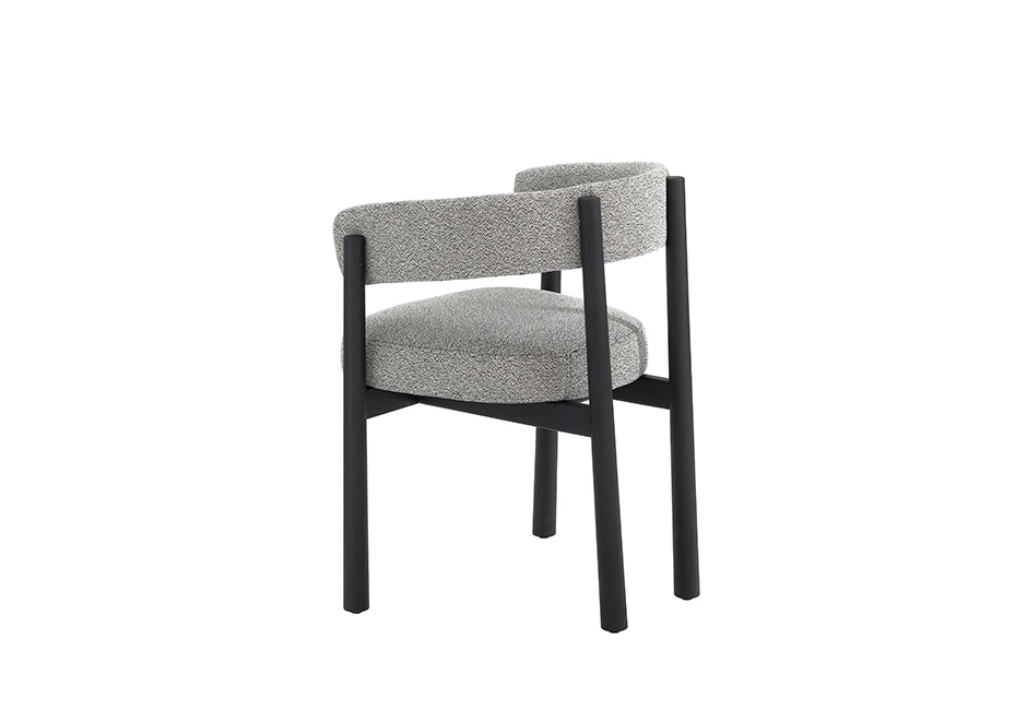 Uma cadeira assinada com estrutura freixo maciço tingido de preto e assento e encosto estofados em tecido cinza, vista de lado em um fundo branco