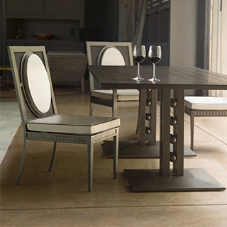 Três cadeiras de design em alumínio com pintura especial branca, em roda de uma mesa, em uma sala.