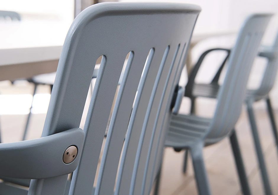 Detalhe de cadeira empilhável, com estrutura de alumínio pintado em poliéster na cor branco.