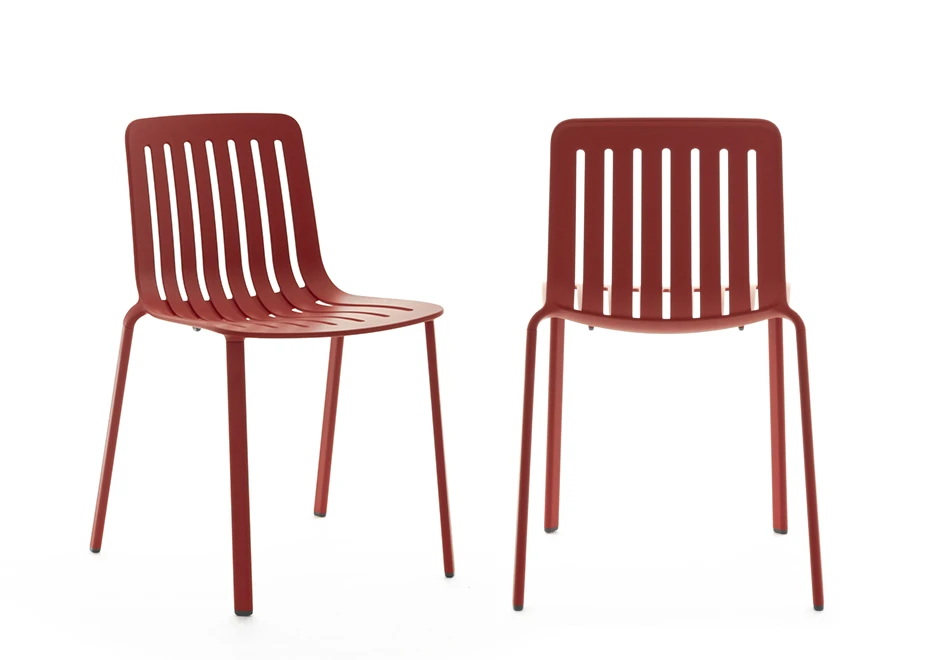 Duas cadeiras empilhaveis, com estrutura de alumínio pintado em poliéster na corvermelho, em um fundo branco.