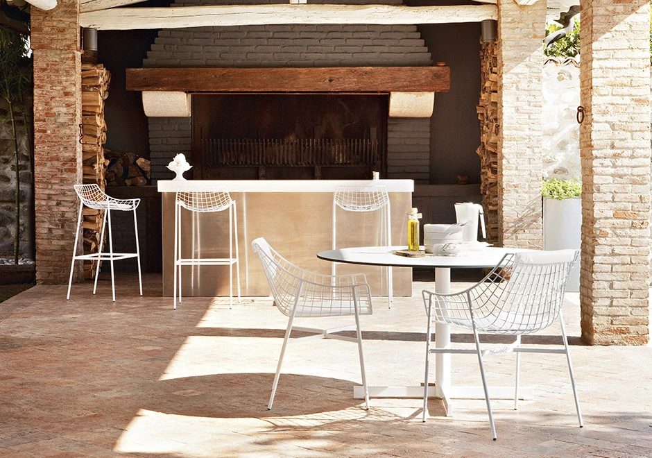 Várias cadeiras de design com estrutura de aço cromado branco, visto em uma area externa.