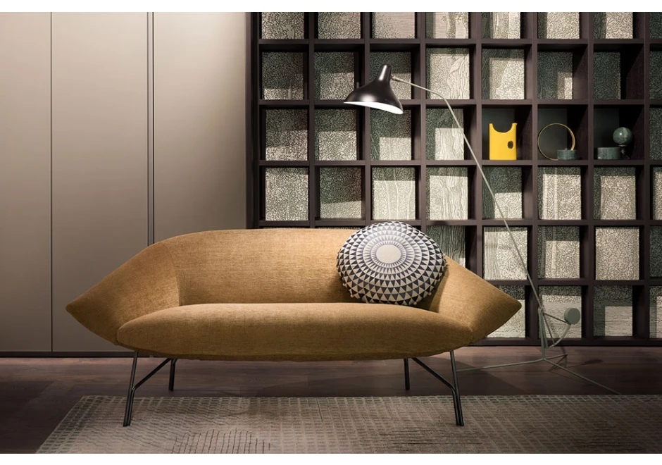 Sofá contemporâneo de 2 lugares com estrutura de metal, estofado em tecido bege, visto de frente, em uma sala moderna.