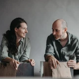 Andrea Forti e Eleonora Dal Farra vestem tons semelhantes próximos ao seu design.