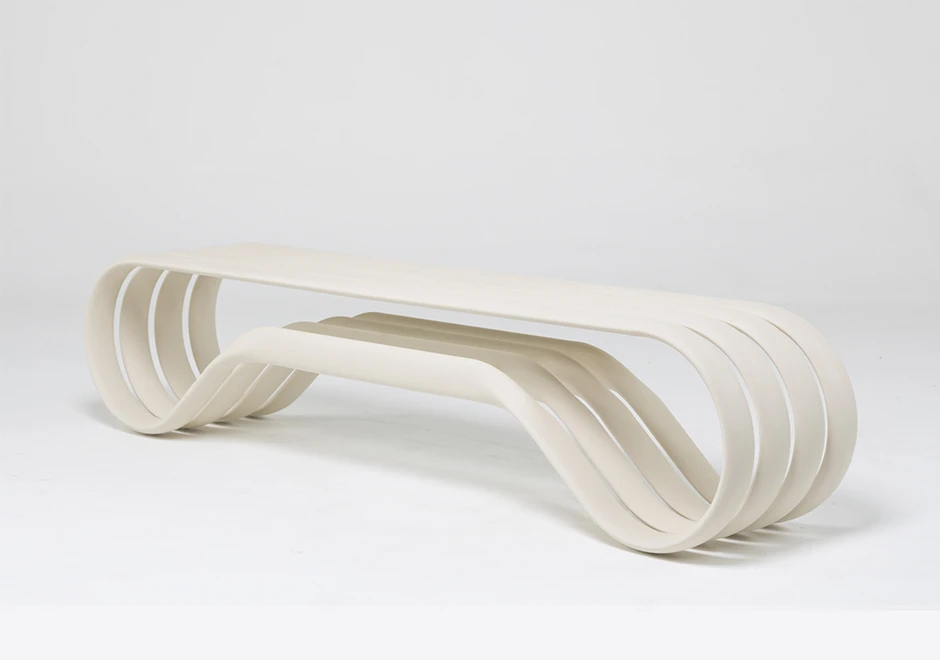 Banco de alumínio pintado de branco, visto de lado, em um fundo branco.