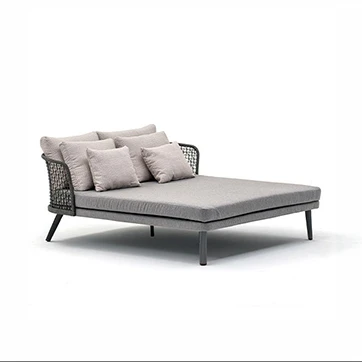 Chaise Daybed com estrutura de alumínio com pintura eletrostática branca; encosto em fibra sintética trançada à mão, pés de alumínio pintado branco, visto de lado em um fundo branco