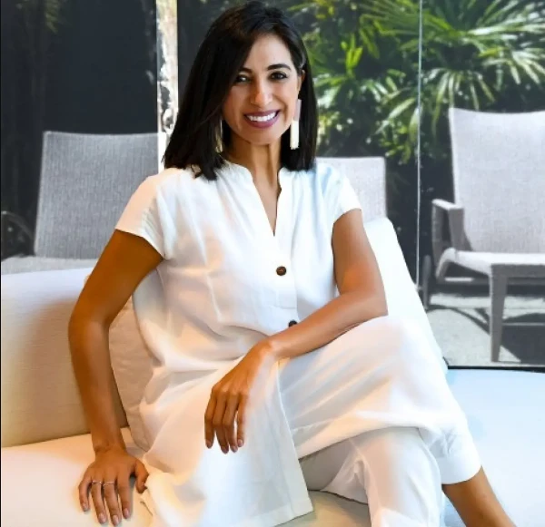 Roberta Banqueri veste branco enquanto posa para foto em ambiente luxuoso.