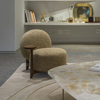 Vista frontal da poltrona Algodão, destacando o apoio e a estrutura em madeira