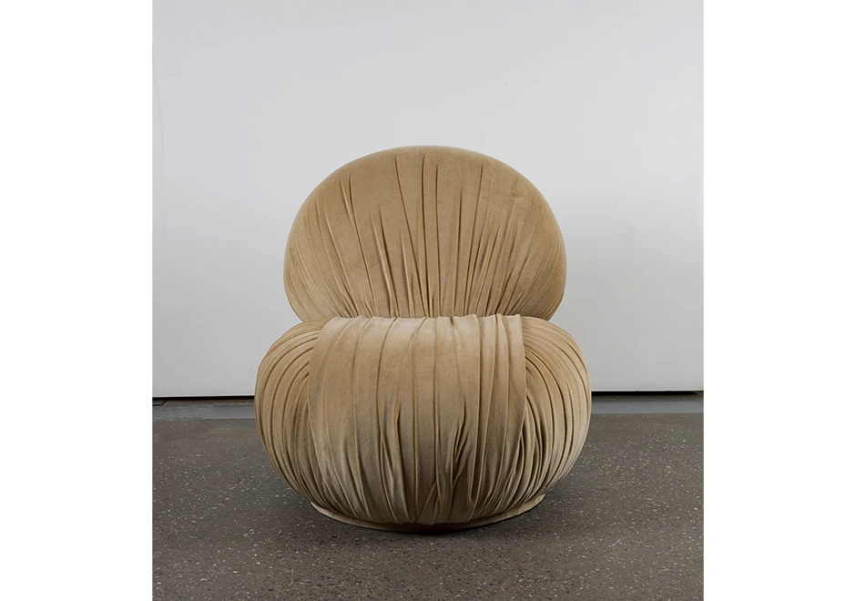 Vista frontal da poltrona Bio, destacando o estofado revestido em tecido franzido.