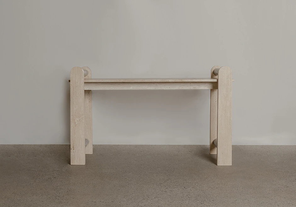 Vista frontal do aparador Farol, destacando o tampo de mármore com marchetaria detalhada e a estrutura em travertino romano bruto.