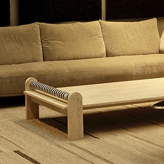 Vista lateral que realça a espessura do tampo em mármore e a estrutura em Travertino Romano Bruto.